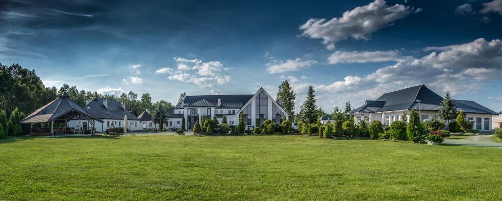 a large house with a large yard with green grass at Hotel Junior in Krakow