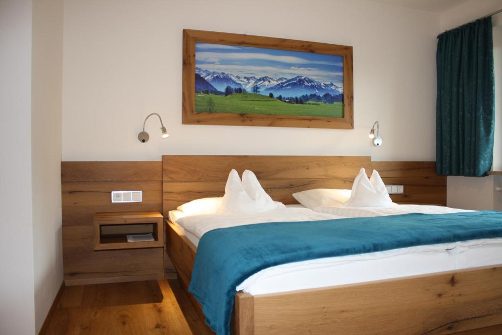 a bedroom with two beds and a painting on the wall at Hotel Gasthof Adler in Oberstdorf