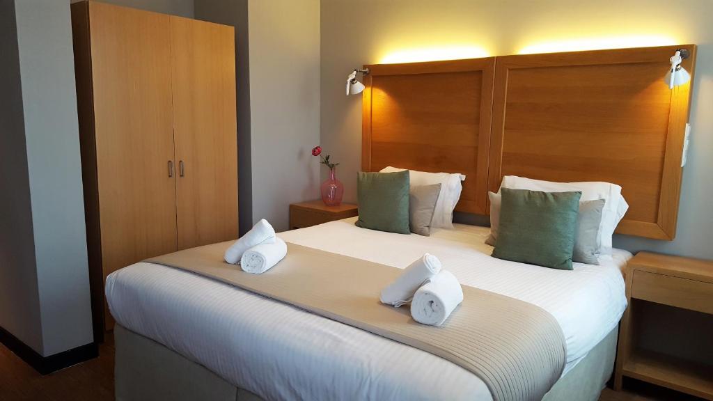 1 dormitorio con 1 cama grande y toallas. en The Bank Hotel, en Ámsterdam