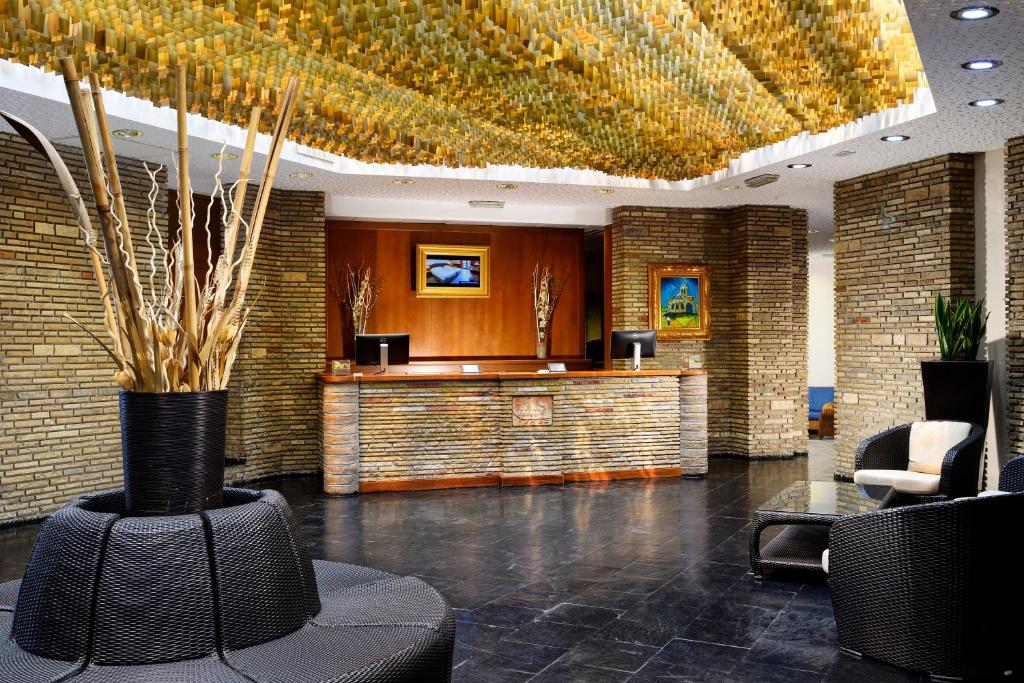 a lobby with a waiting area with chairs and a bar at UNA HOTELS Capotaormina in Taormina
