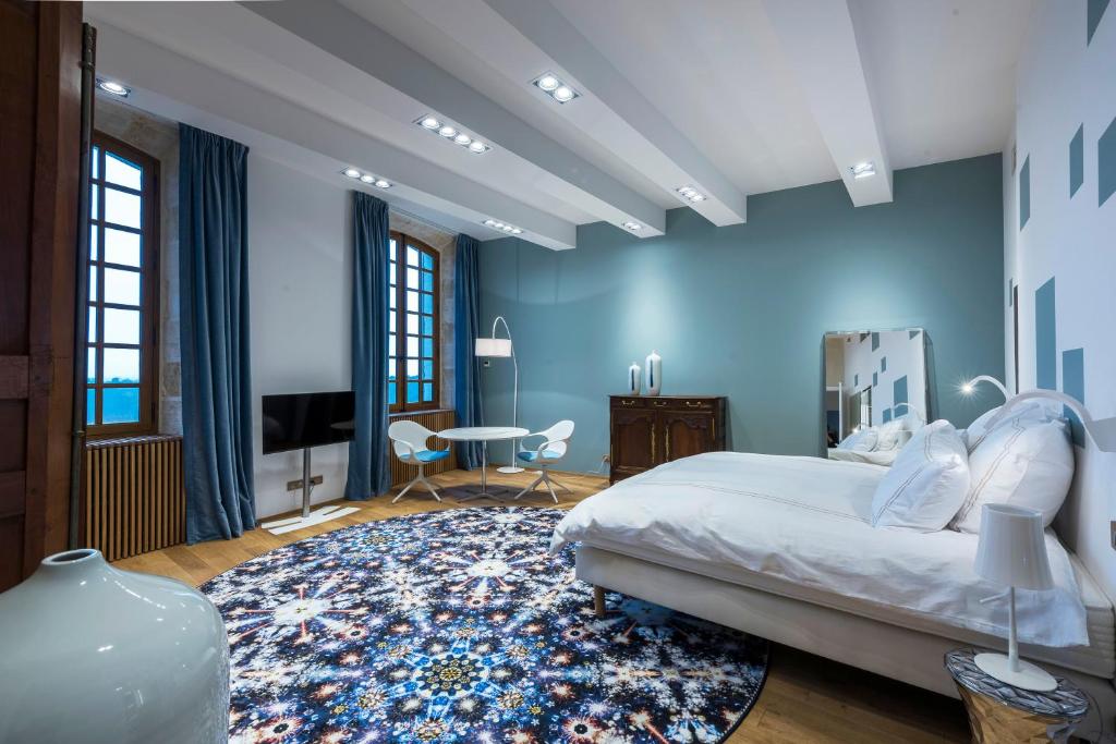 - une chambre avec un lit et un mur bleu dans l&#39;établissement Chateau Prieure Marquet, à Saint-Martin-du-Bois