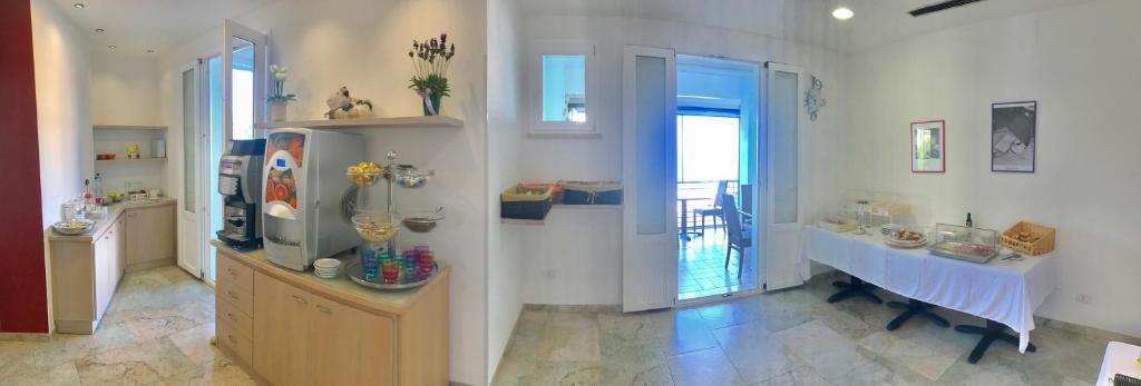 a living room with a table and a room with a window at Hotel Aurora in San Vincenzo