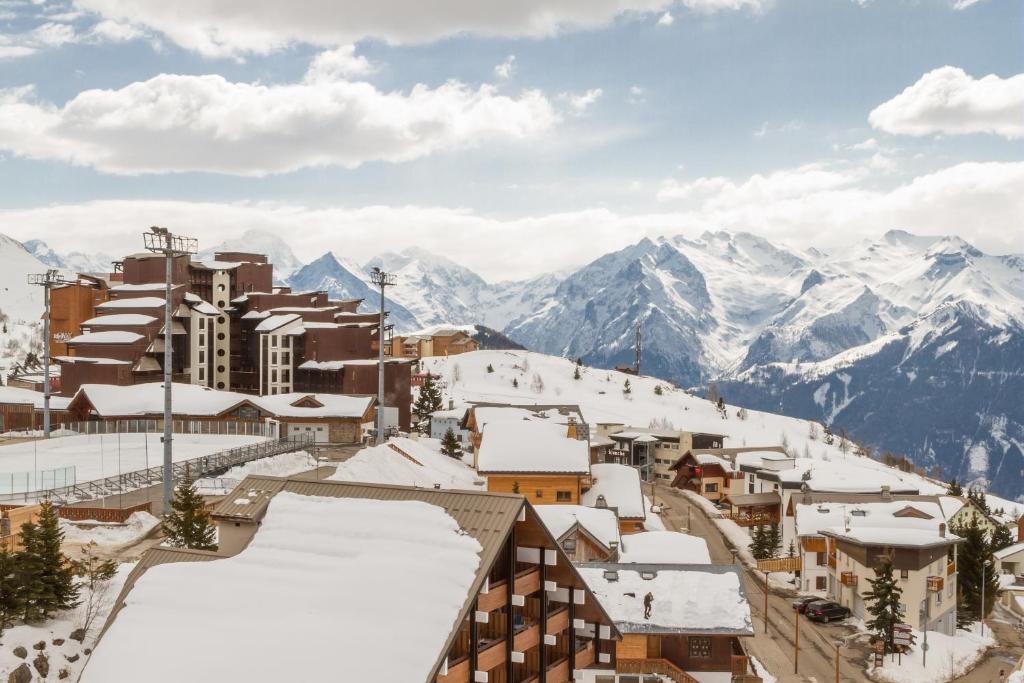 a town covered in snow with mountains in the background at Residence L'Ours Blanc - maeva Home in L'Alpe-d'Huez
