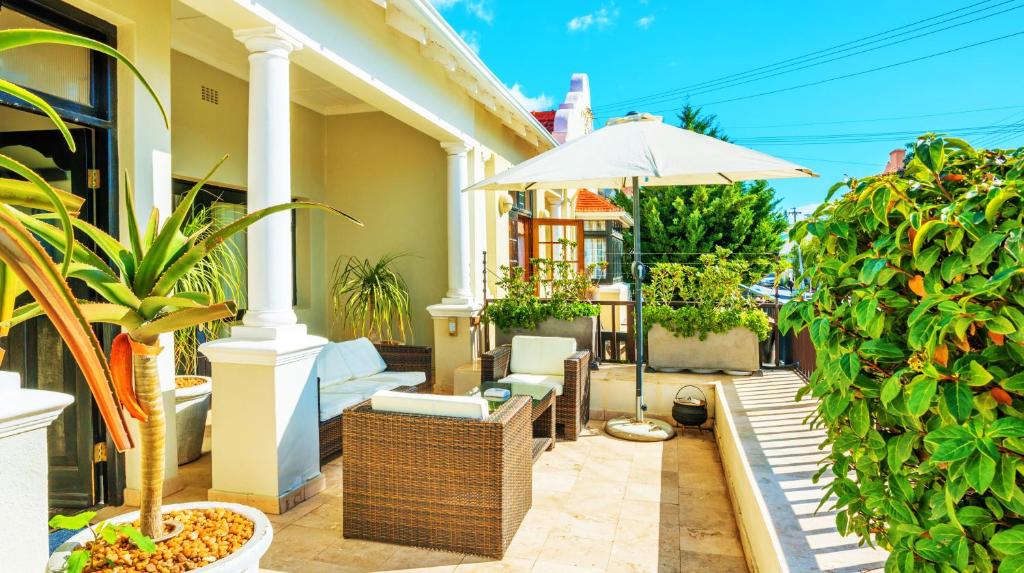 une terrasse avec des plantes et un parasol sur une maison dans l'établissement Antrim Luxury Villa, au Cap