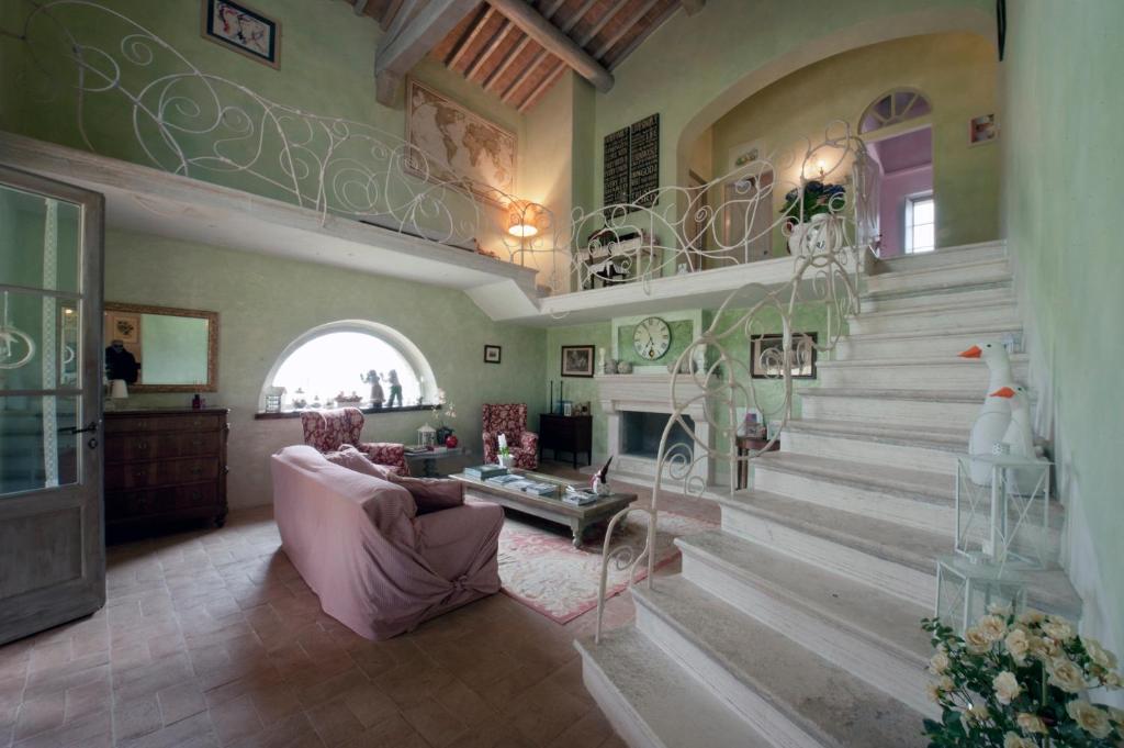 a living room with a staircase with a couch and a table at La casa di Arianna in Casole dʼElsa