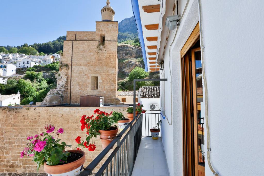 balkon z kwiatami w doniczkach na budynku w obiekcie Apartamentos Castillo Cazorla w mieście Cazorla