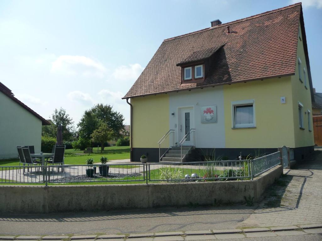 a yellow house with a fence in front of it at FrankenFeWo in Neusitz