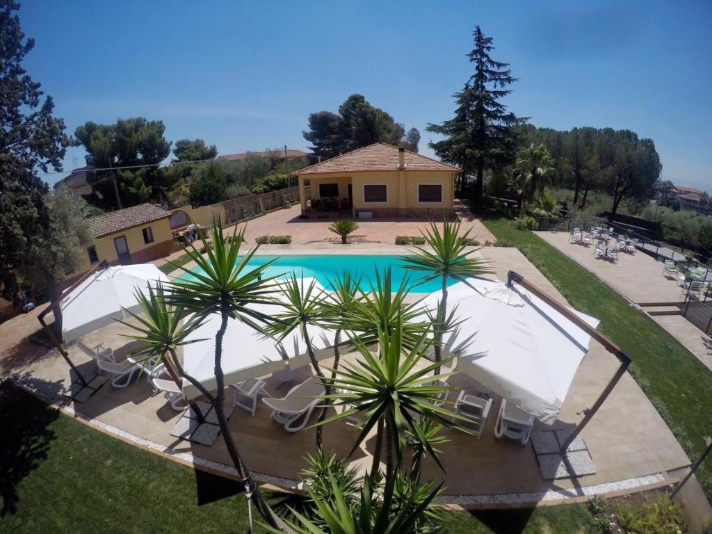 an aerial view of a pool with umbrellas and a house at Il Giardino di Agata in Mascalucia