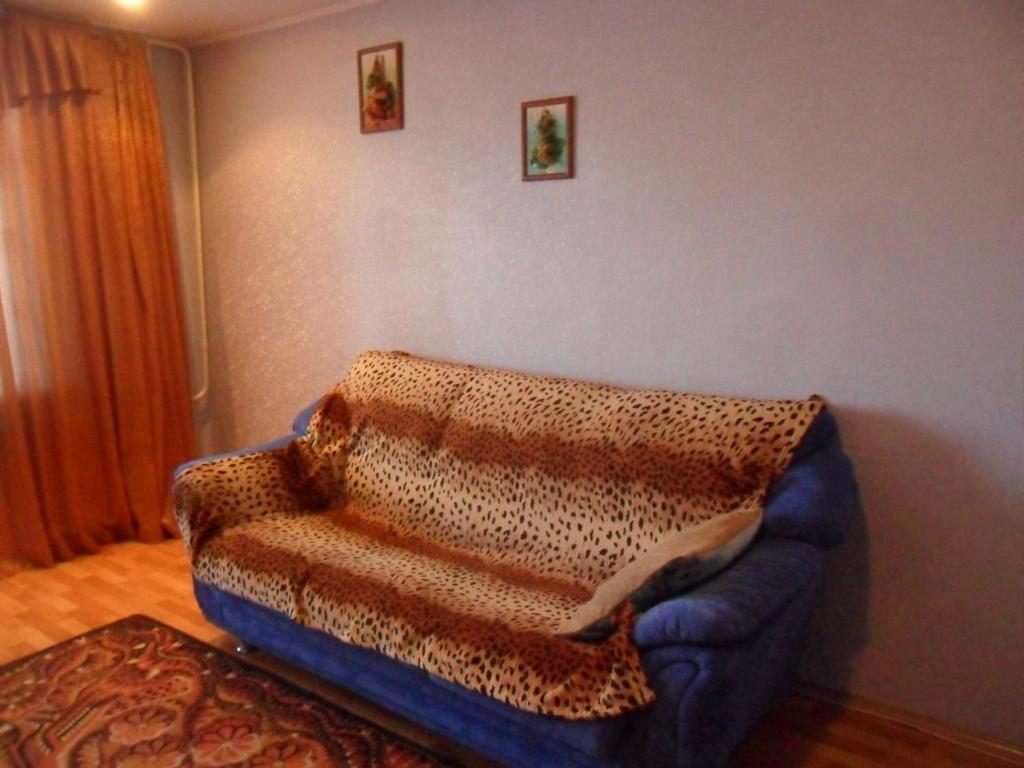 クルガンにあるтрехкомнатная квартира д 3のリビングルーム(毛布付きの青いソファ付)