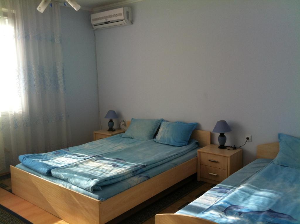 1 dormitorio con 2 camas y ventana en Family Hotel Velevi, en Velingrad