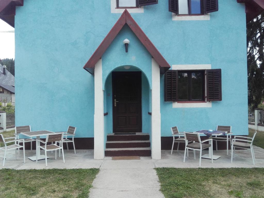 a blue house with tables and chairs in front of it at Apartments Vila Marija in Žabljak