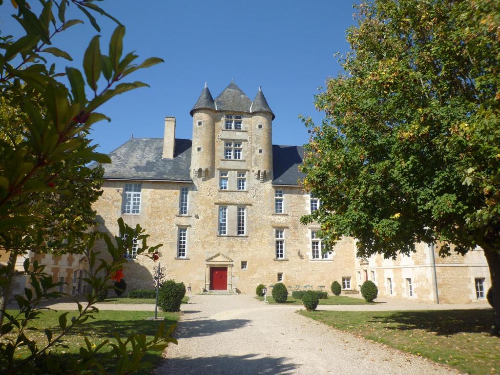 un vieux château avec une porte rouge dans une cour dans l'établissement Château d'Avanton, à Avanton
