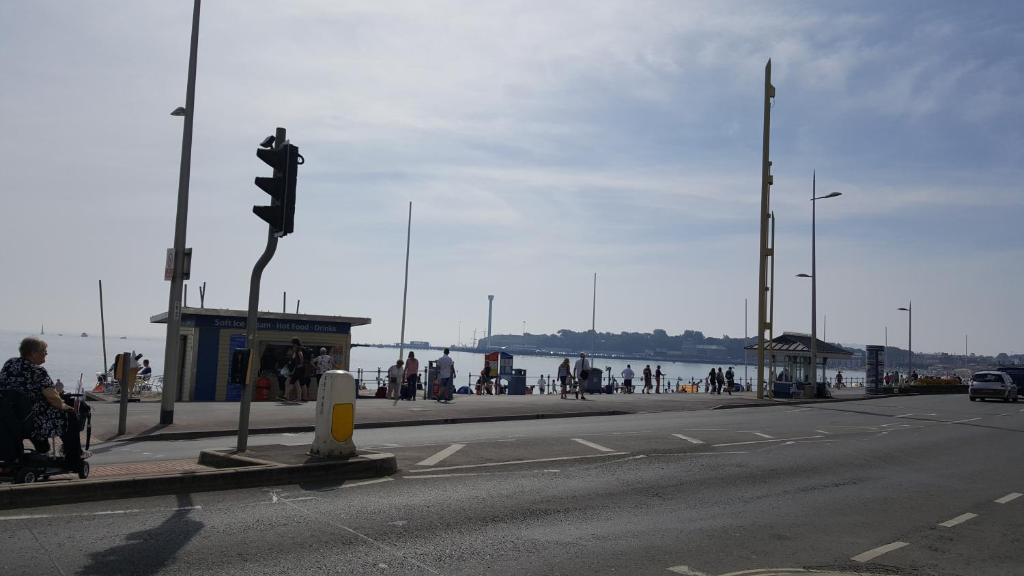 a street with a traffic light and people on the beach at 1 bed self catering apartment in Weymouth