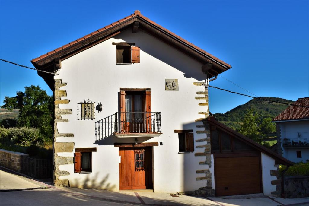 ein weißes Haus mit einem Balkon an der Seite in der Unterkunft Casa Artegia in Mezkiriz