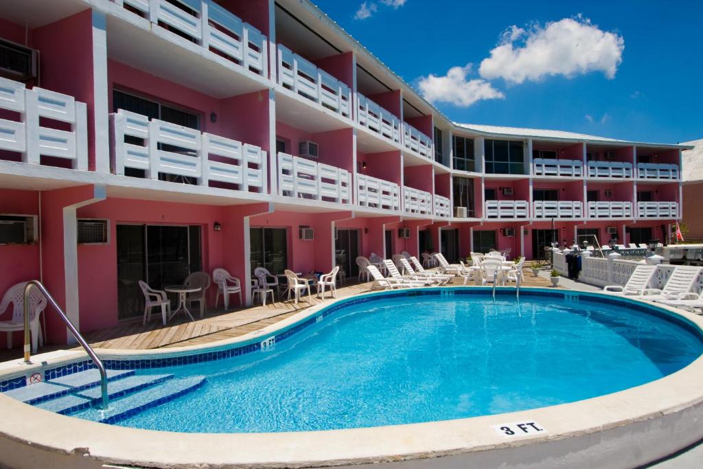 a hotel with a swimming pool and patio furniture at Bell Channel Inn Hotel in Freeport