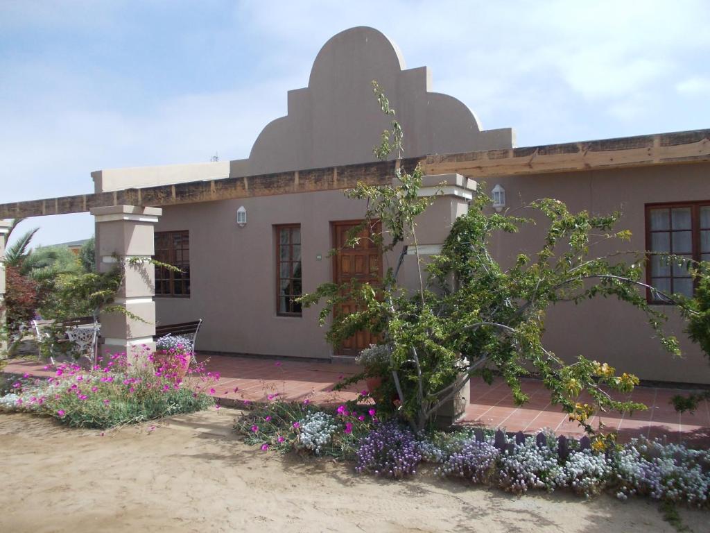 a house with flowers in front of it at Huis KlipdriftSelf Catering &B&B in Hentiesbaai