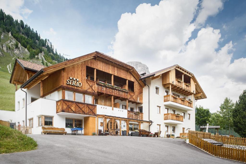 a building in the mountains with a road in front at Garnì Sirio in Colfosco