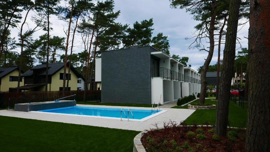 波皮耶洛伯的住宿－Pobierowo Apartments，庭院中带游泳池的房子