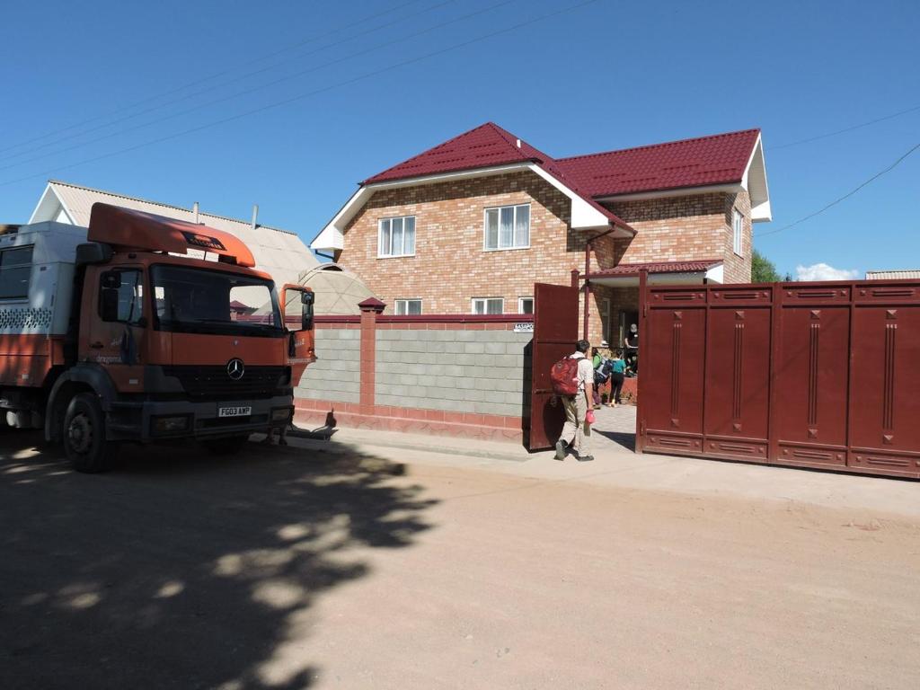 un camion benne garé devant un bâtiment dans l'établissement Guest House Ulukbek, à Bokonbayevo