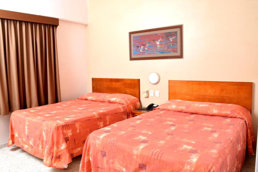 Postel nebo postele na pokoji v ubytování Hotel Delfines - a 2 calles del Acuario Veracruz