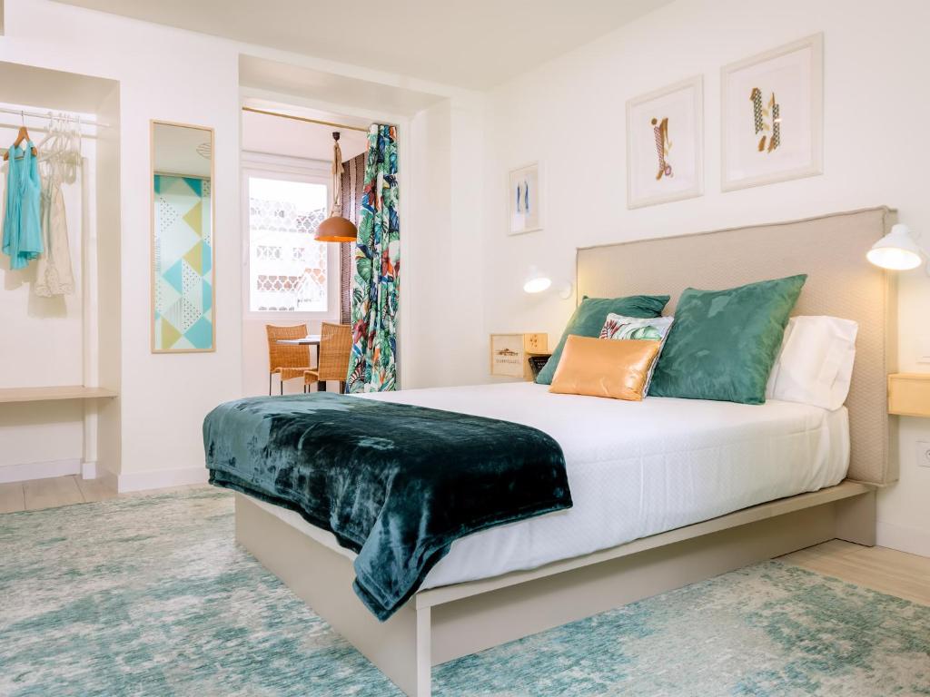 a bedroom with a bed with green and orange pillows at HABITAKA, Hogares de paso in Vitoria-Gasteiz