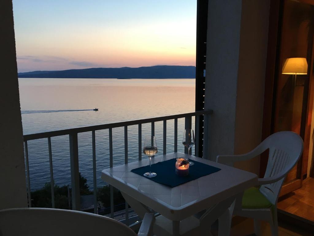 a table and chairs on a balcony with a view of the water at Apartman Mimoz in Senj