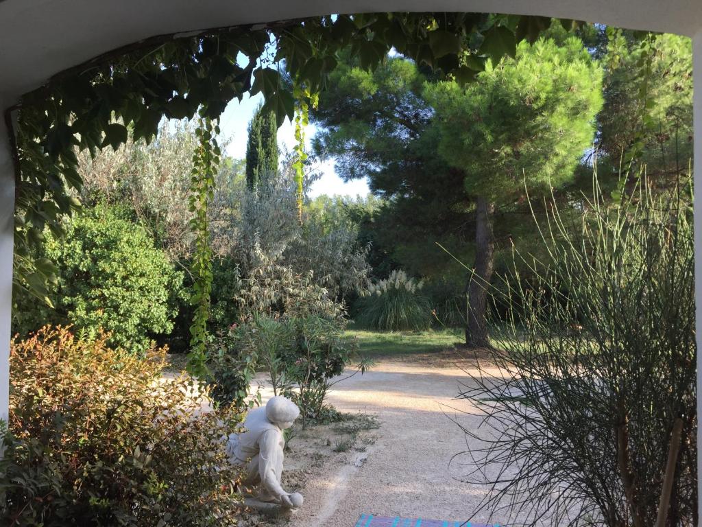 une statue d'un ours en peluche assis dans un jardin dans l'établissement La Maison des Voyageurs, à Arles
