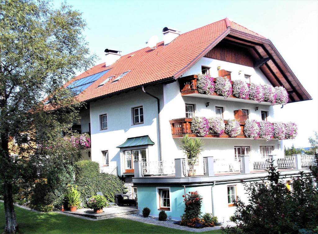 a large white building with flower boxes on it at Pension Waldhof in Koppl