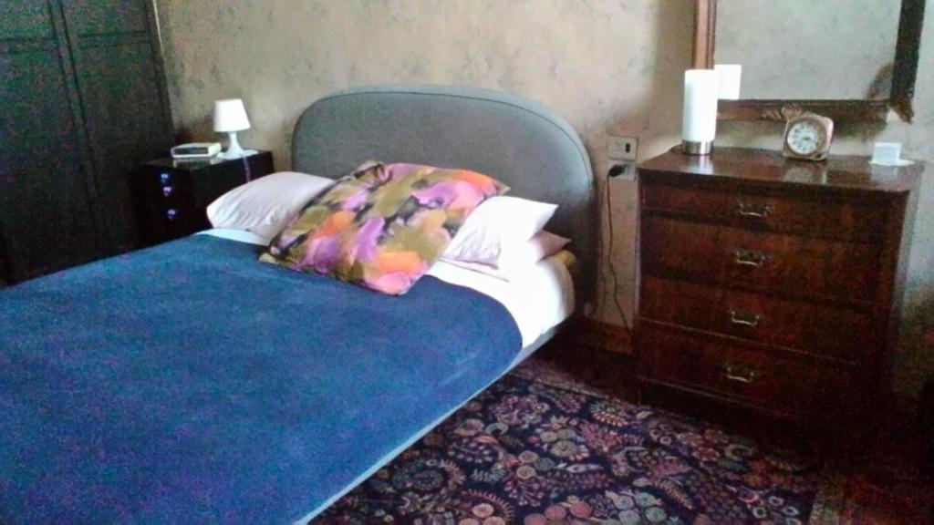 オルヴィエートにあるCharming Apartmentのベッドルーム1室(青い毛布、ドレッサー付)
