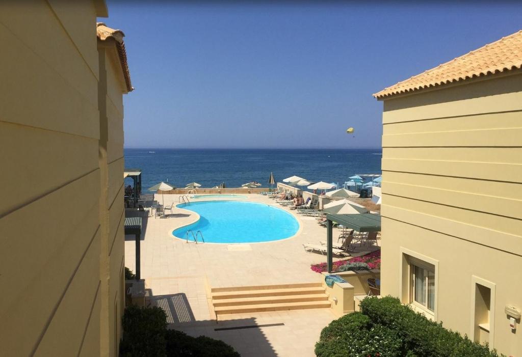 a view of a swimming pool and the ocean at Lissos Beach in Plataniás