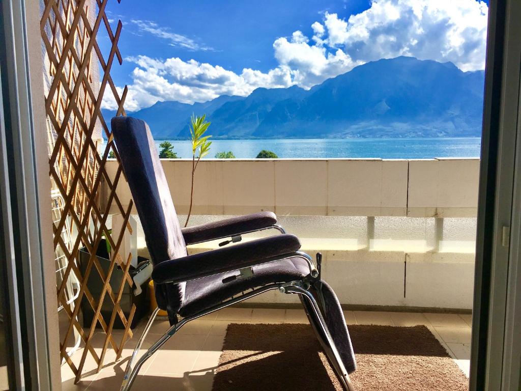 a chair sitting on a balcony with a view of the ocean at Spacious Apartment with Lake View | 35 in Montreux