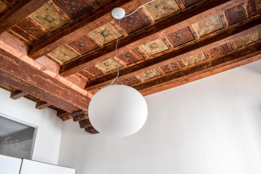 una luce bianca appesa a un soffitto di legno di Casa degli Scacchi a Mantova
