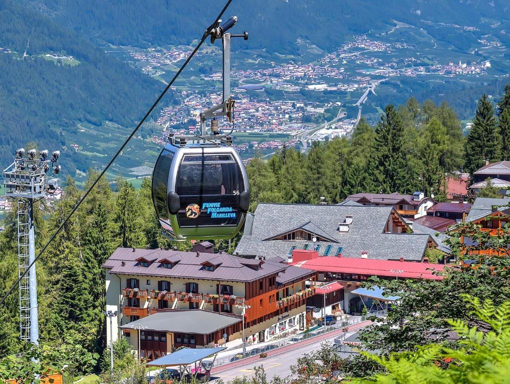 a gondola flying over a town on a mountain at Hotel Caminetto in Folgarida