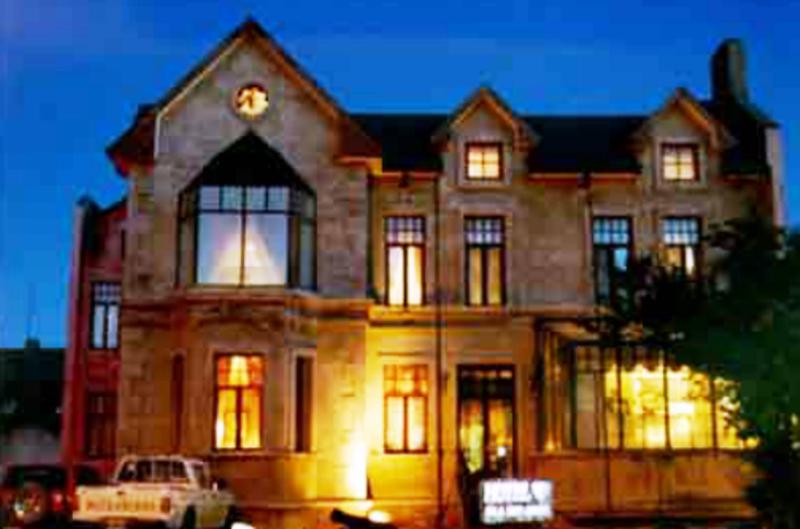 a large house with a car parked in front of it at Hotel Isla Rey Jorge in Punta Arenas