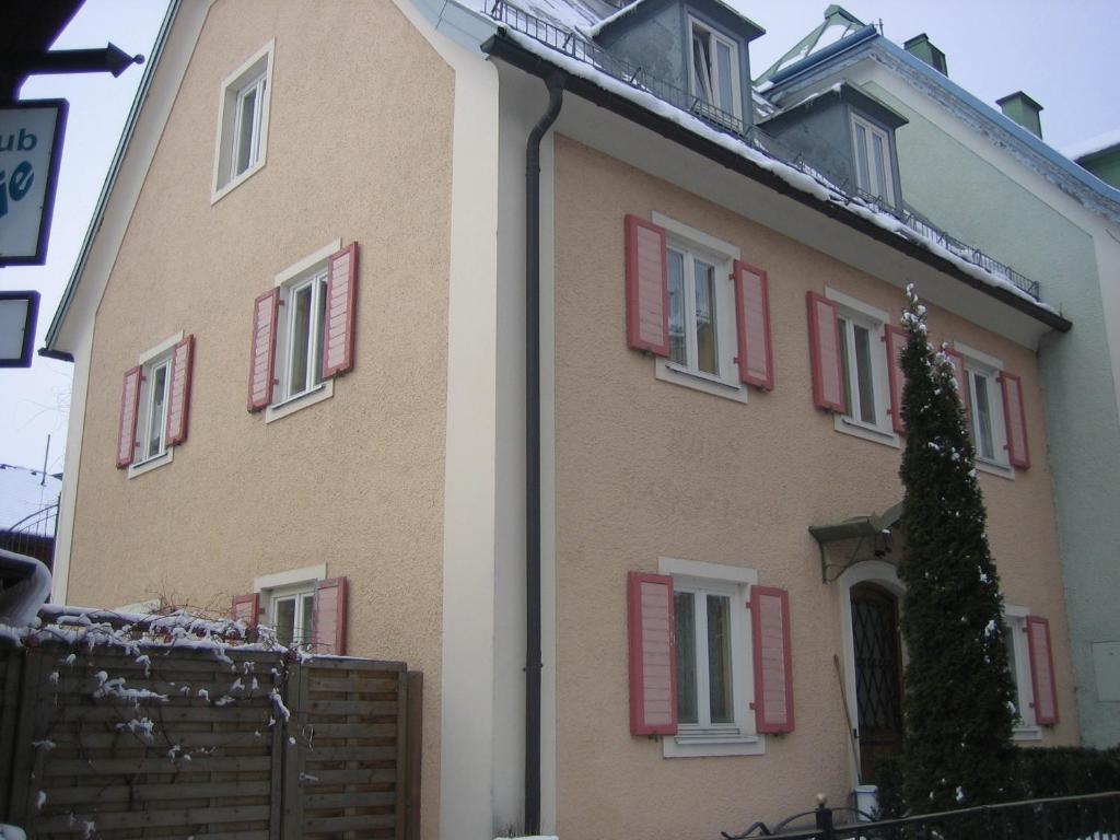 ein großes Haus mit roten Rollläden drauf in der Unterkunft Ferienwohnung Gastein in Bad Hofgastein