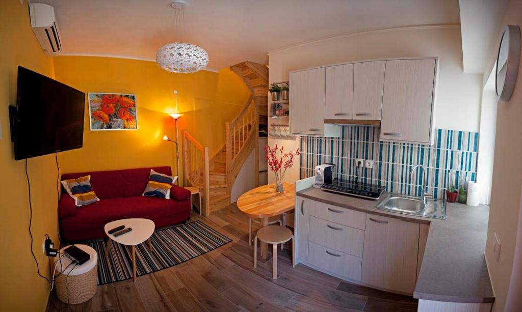 Il comprend un salon avec un canapé rouge et une cuisine. dans l'établissement Apartment Koper, à Koper