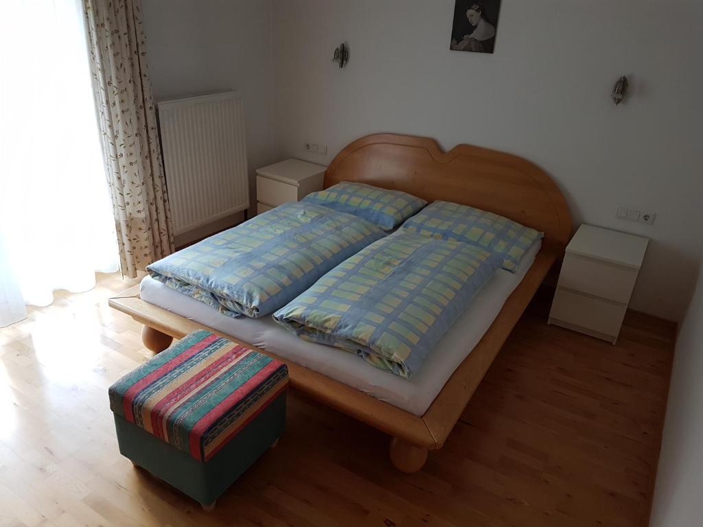 Bett mit einem Kopfteil aus Holz in einem Schlafzimmer in der Unterkunft Haus Fischer in Dorfgastein