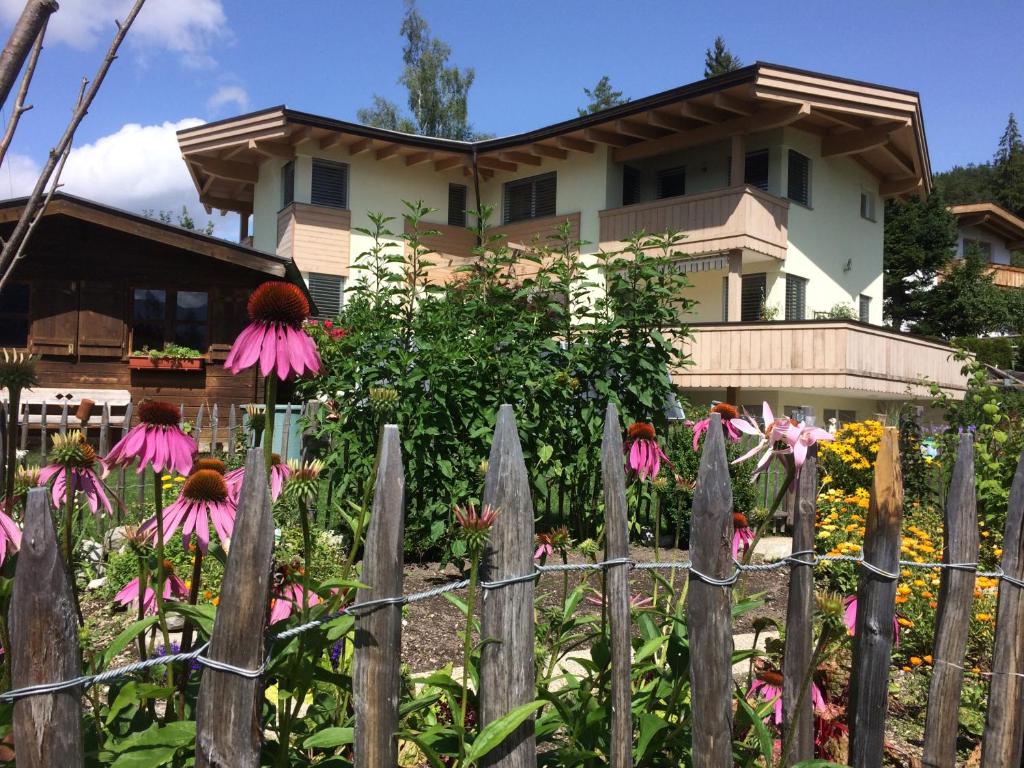 uma cerca em frente a uma casa com flores em Krinzerhäusl em Seefeld in Tirol