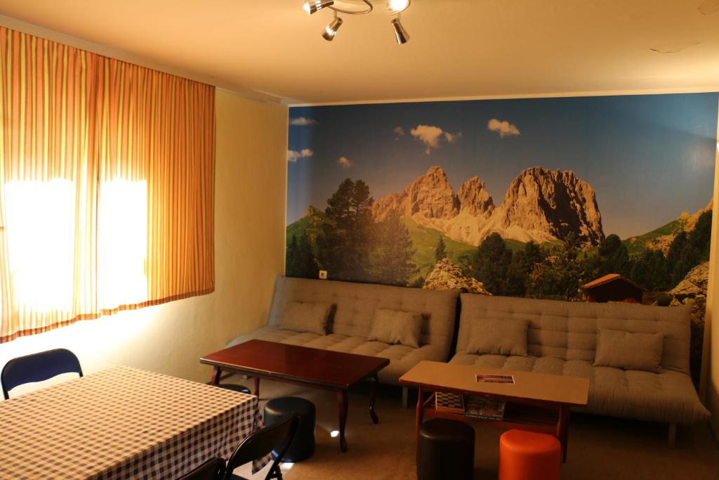 a living room with a couch and a mountain mural at Hostel Trajan in Donji Milanovac