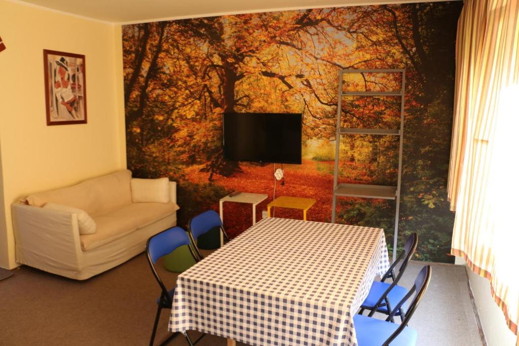 a living room with a table and a tv on a wall at Hostel Trajan in Donji Milanovac
