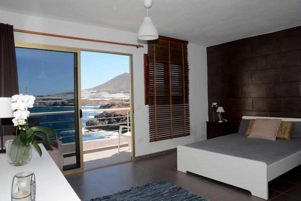 a bedroom with a bed and a view of the ocean at Galdar GC Vistas al Mar in Gáldar