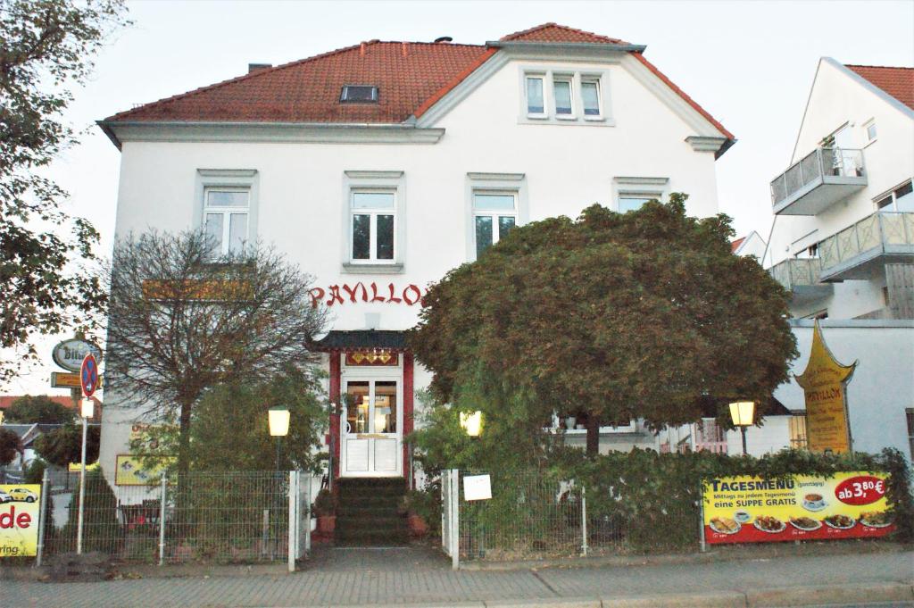 Uma casa branca com um cartaz. em Gasthaus Pavillon em Dresden