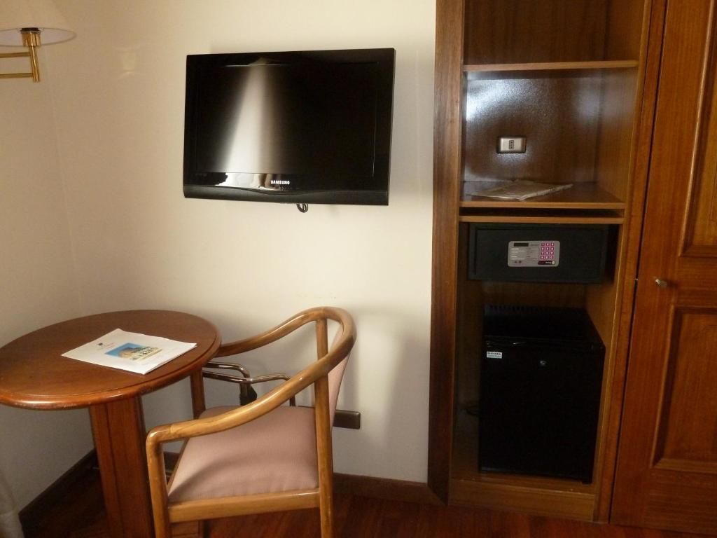 a tv sitting on top of a wooden stand at Hotel Francisco De Aguirre in La Serena