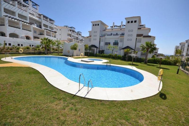 una gran piscina frente a algunos edificios en Residential Duquesa, en San Luis de Sabinillas