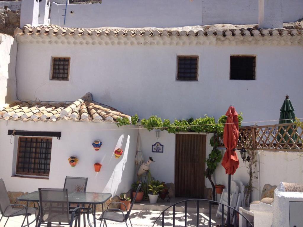 a patio with a table and chairs and a building at Cueva Chelaja in Galera