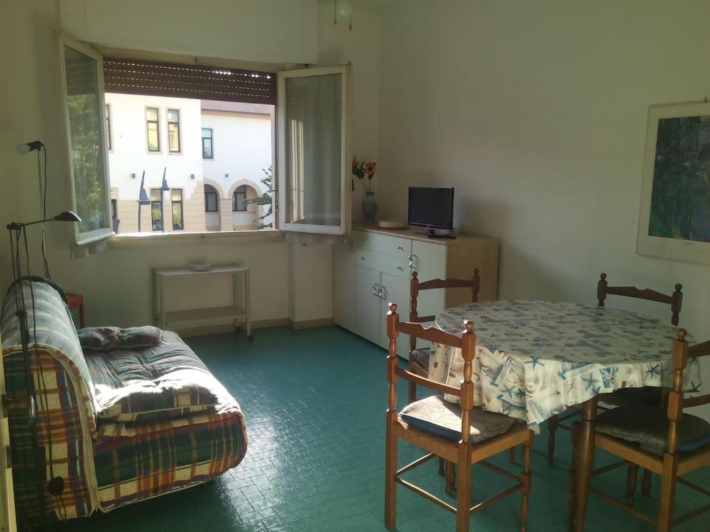 カスティリオーネ・デッラ・ペスカーイアにあるAppartamento l'Approdoのテーブルとベッド、窓が備わる客室です。