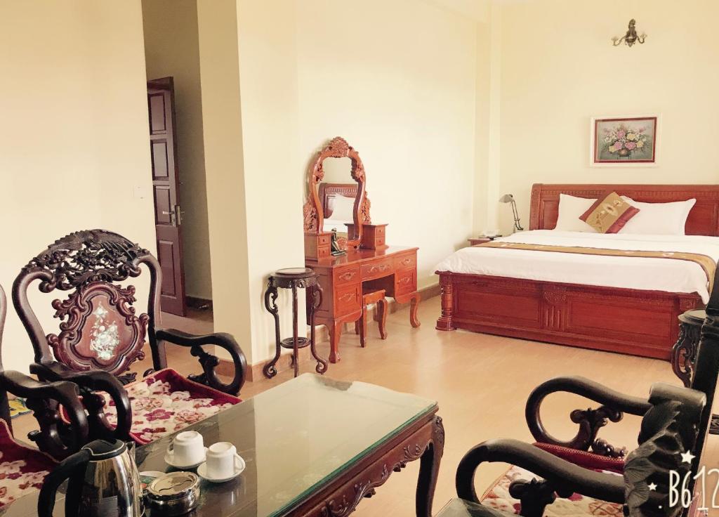 1 dormitorio con 1 cama, mesa y sillas en Binh Minh Hotel, en Ninh Binh