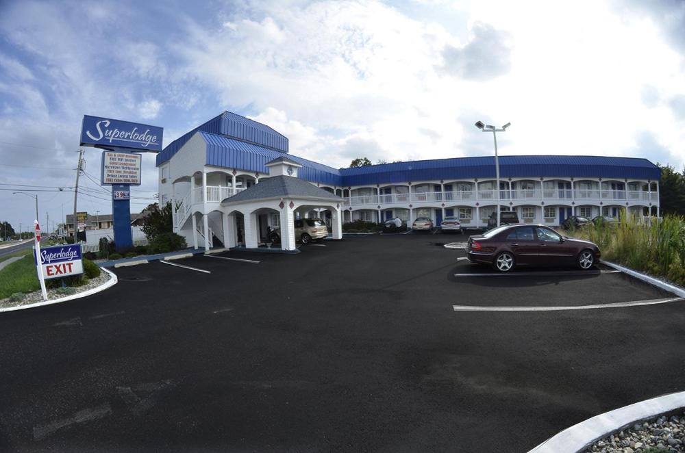 un gran edificio con un coche aparcado en un aparcamiento en Superlodge Absecon/Atlantic City, en Absecon