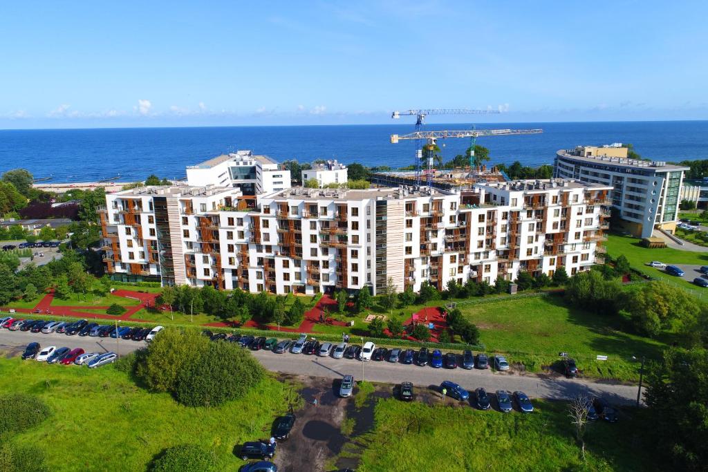 una vista aérea de un gran edificio de apartamentos con aparcamiento en Apartamenty Olympic Park, en Kołobrzeg