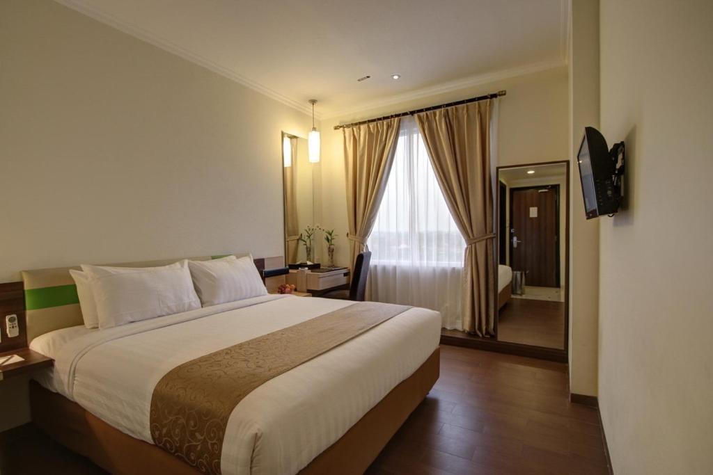 Postel nebo postele na pokoji v ubytování Hotel Dafam Pekalongan